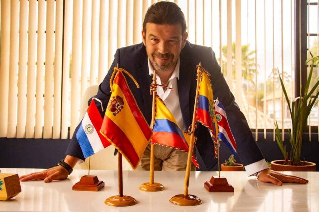 Dr. Alfonso F. Algora en su oficina con las banderas de los países donde Iberoeduca tiene presencia